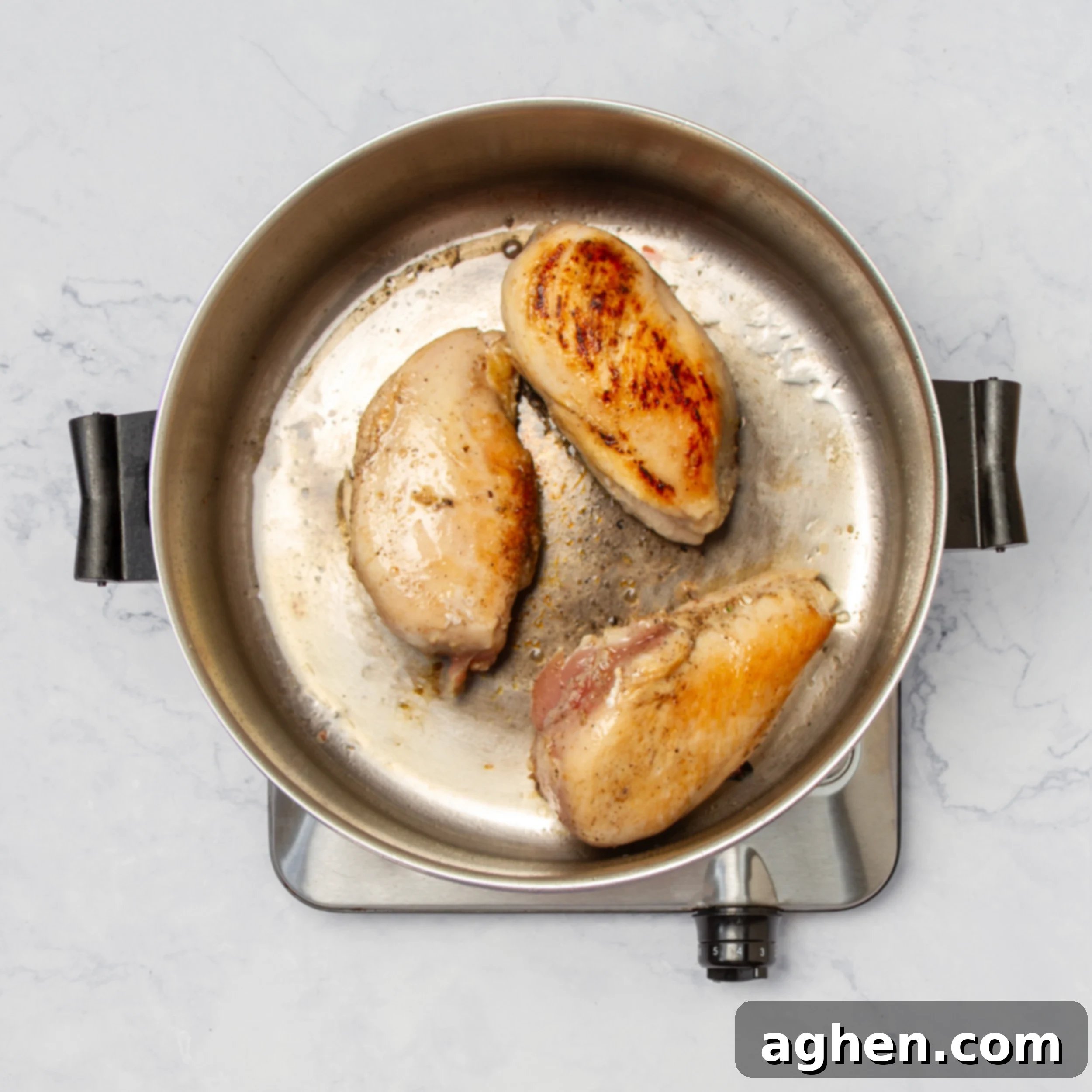 Weight Watchers' Iconic Chicken Primavera 5 Chicken breasts cooking in a hot skillet, developing a golden-brown sear.