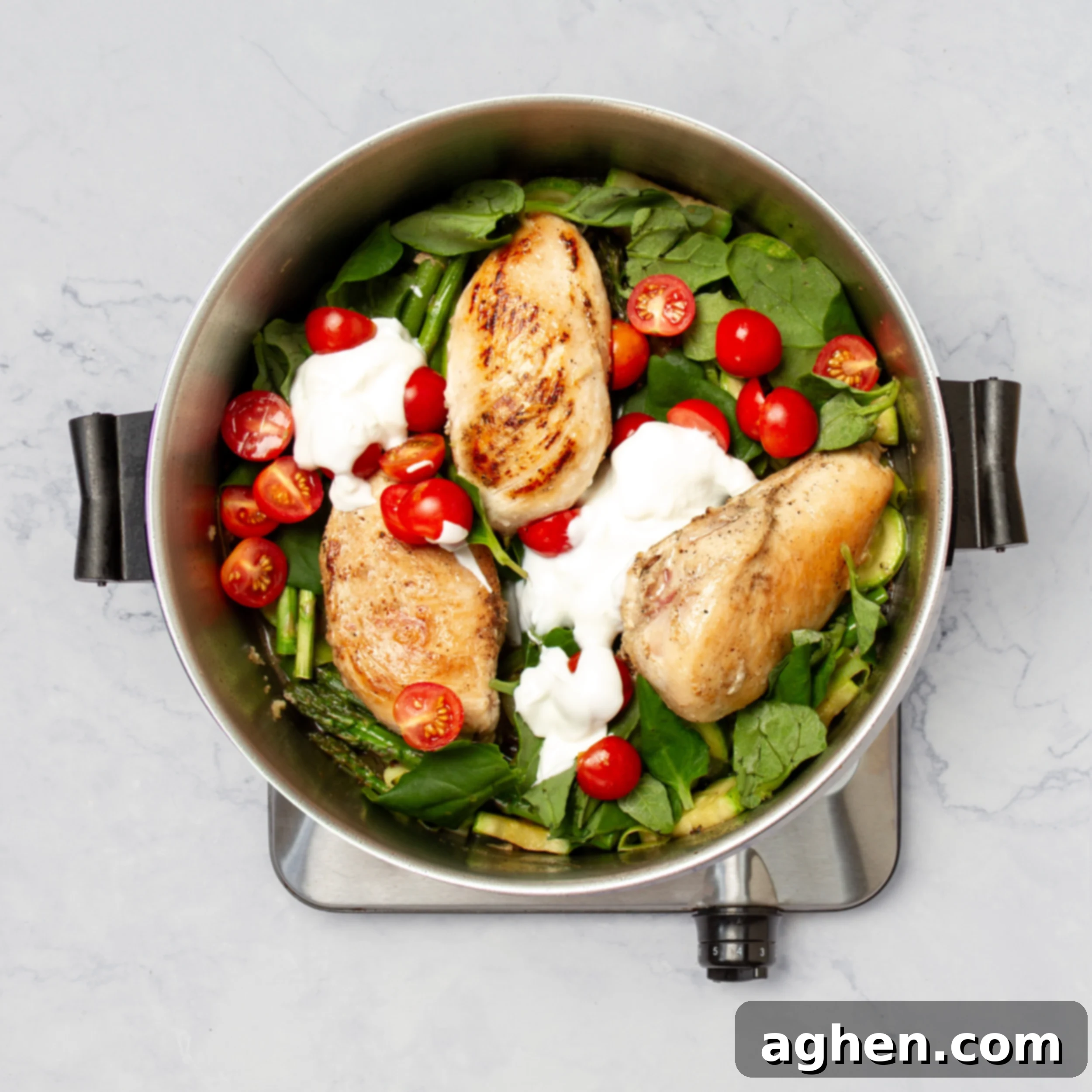 Weight Watchers' Iconic Chicken Primavera 7 Fresh spinach, halved cherry tomatoes, and creamy yogurt being stirred into the pan with chicken and vegetables, forming the light sauce.