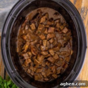 Crockpot steak bites in au jus sauce with garlic and sweet onions.