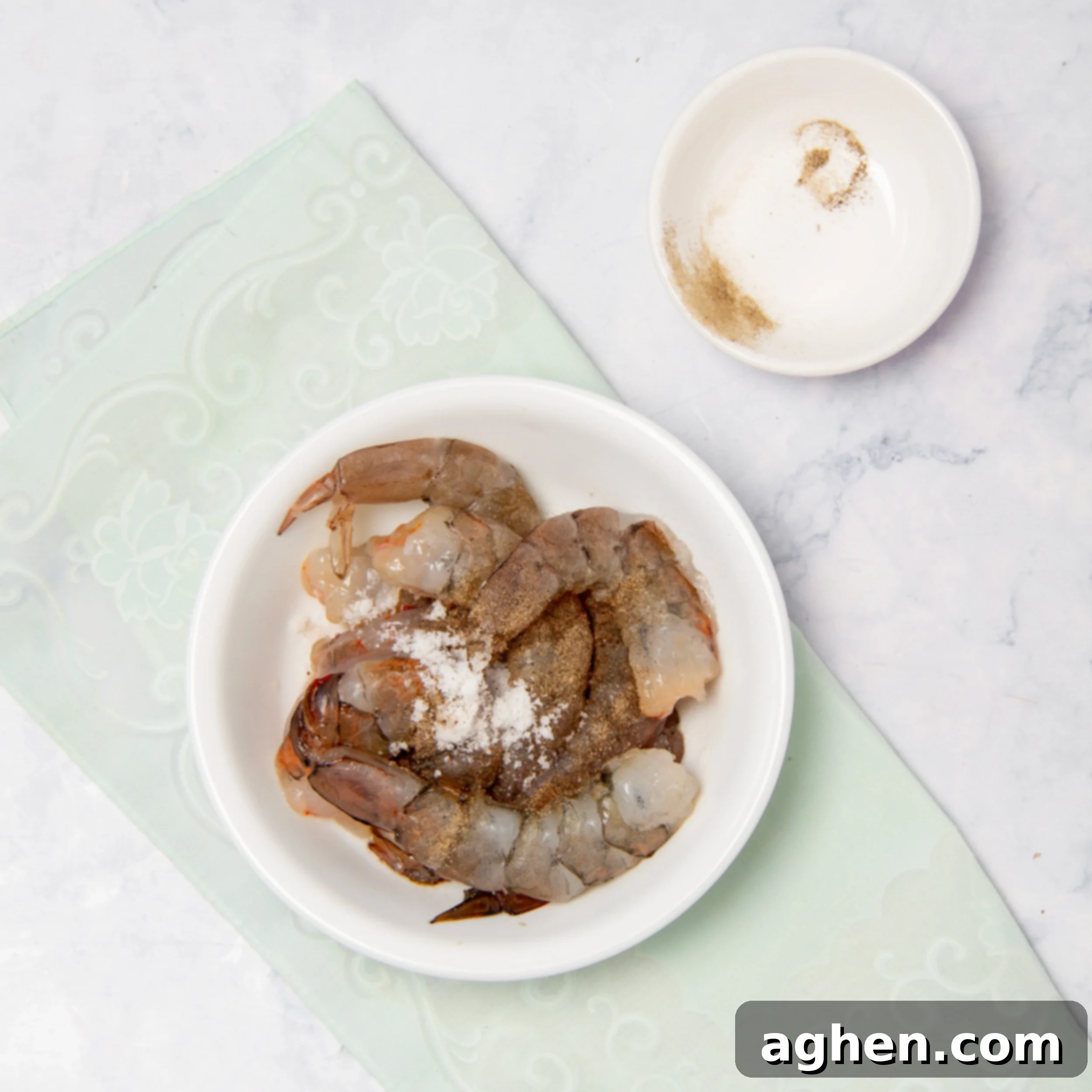 Raw shrimp marinating in a small bowl, ready for cooking.