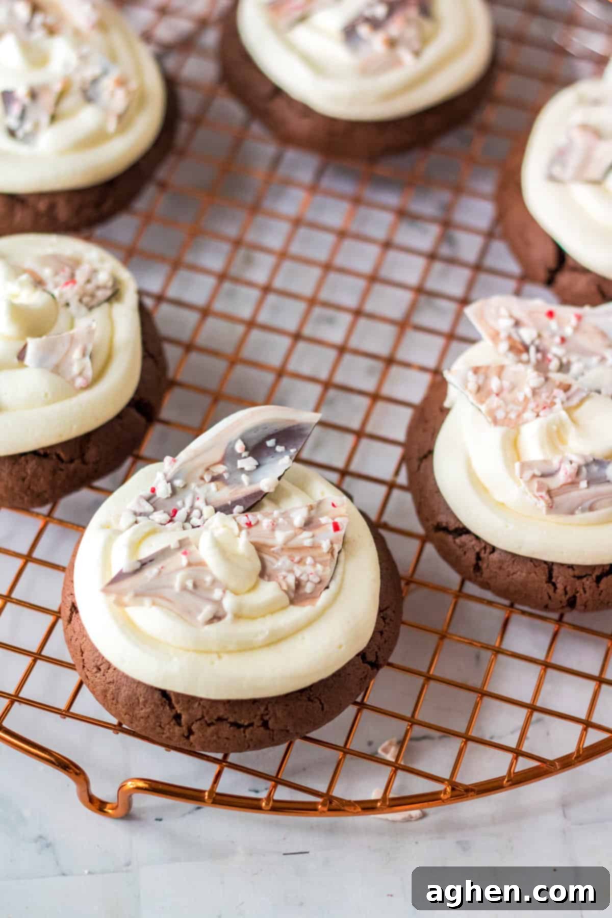 Finished Chocolate Peppermint Bark Cookies, beautifully frosted and topped with crunchy bark pieces, arranged on a wire rack.