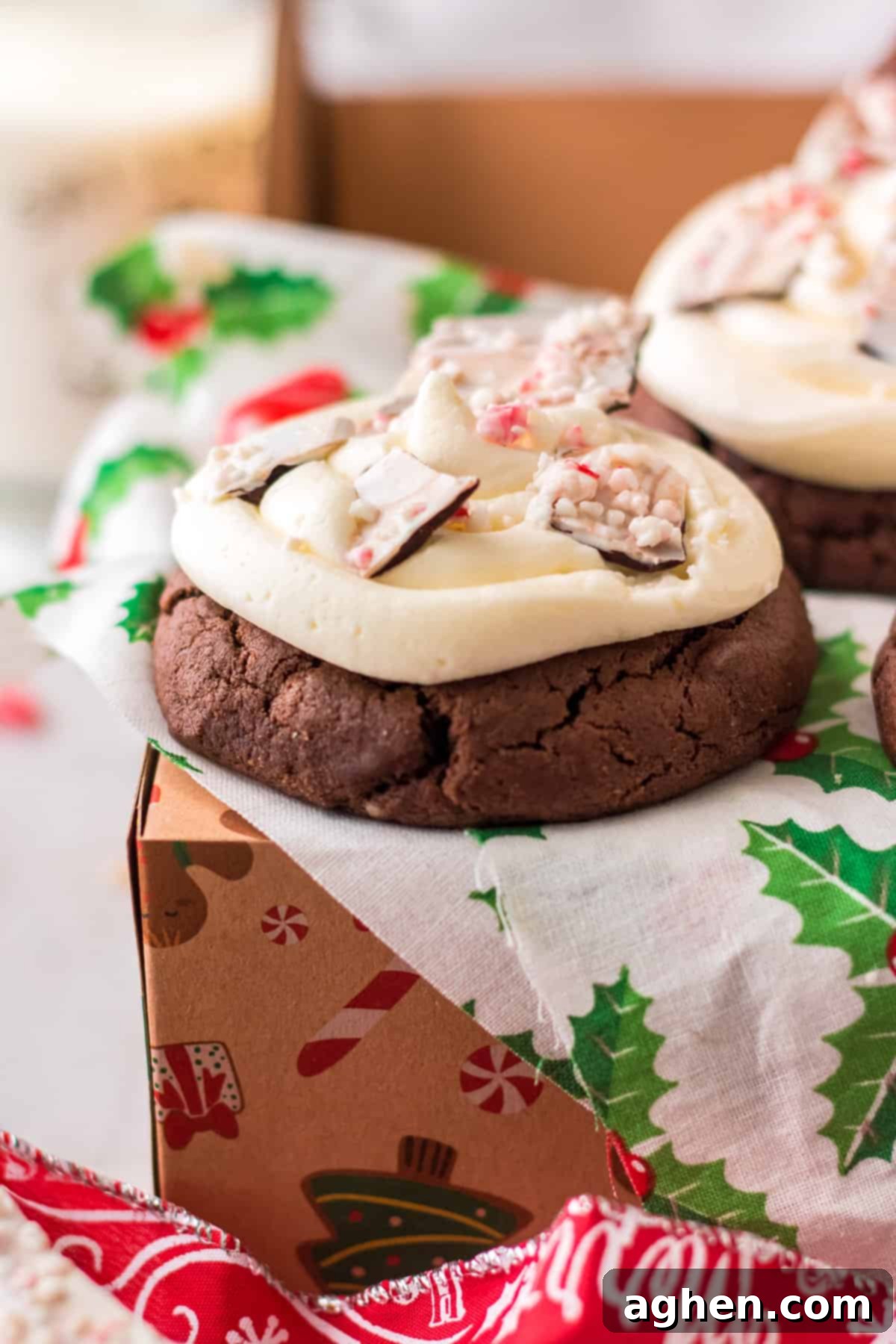 Close-up of a single chocolate peppermint cookie featuring a luscious swirl of buttercream frosting and perfectly placed peppermint bark pieces.