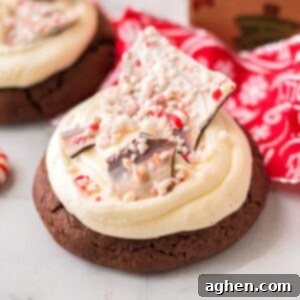 Thick chocolate cookie with buttercream frosting and shards of homemade peppermint bark.