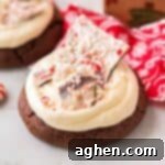 Thick chocolate cookie with buttercream frosting and shards of homemade peppermint bark.