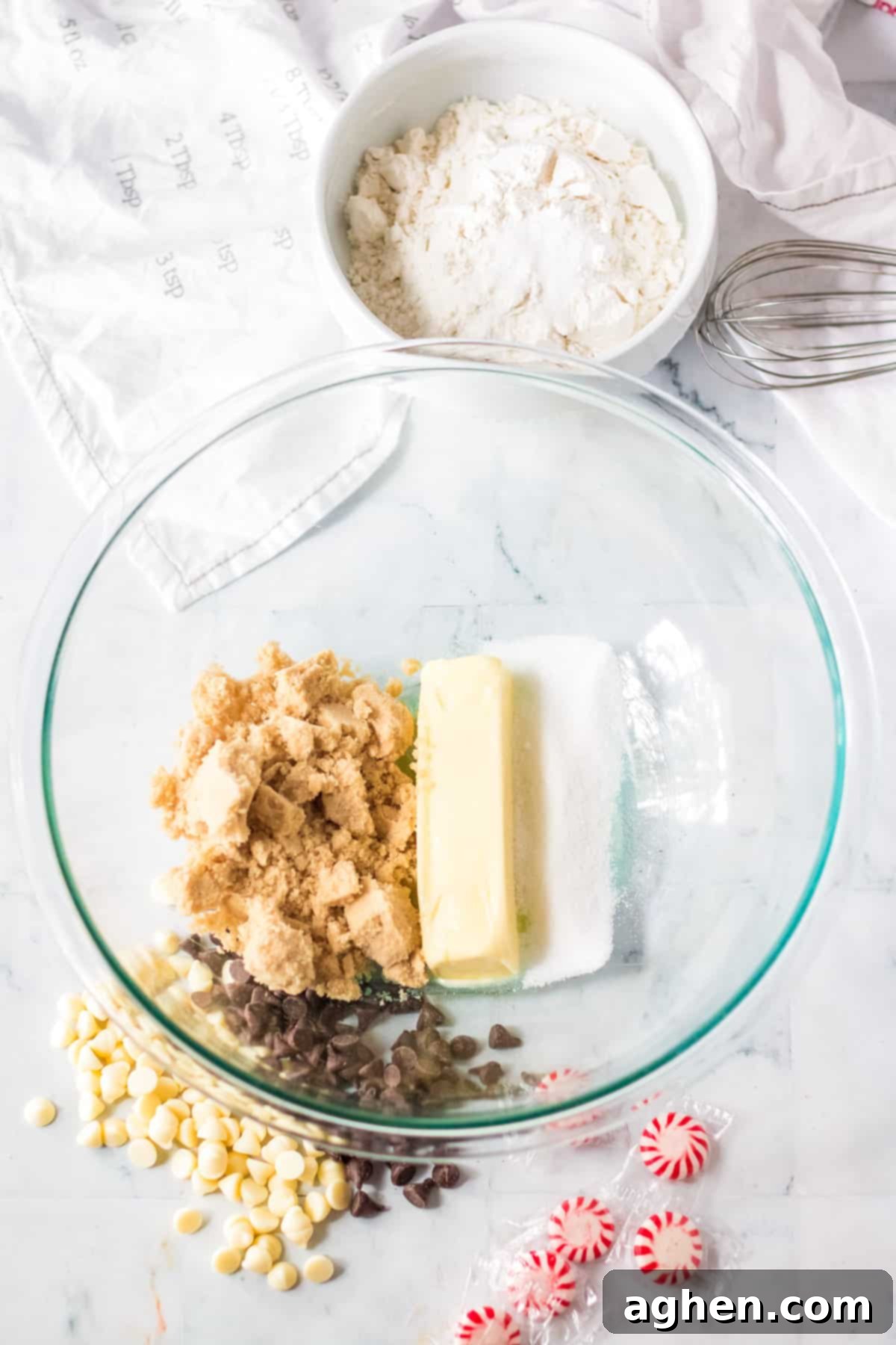 Room temperature butter, light brown sugar, and granulated sugar ready to be creamed in a glass mixing bowl.