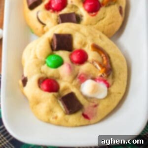 Kitchen sink cookies with Christmas M&Ms, mini marshmallows, pretzel pieces, and chocolate chunks, beautifully arranged.