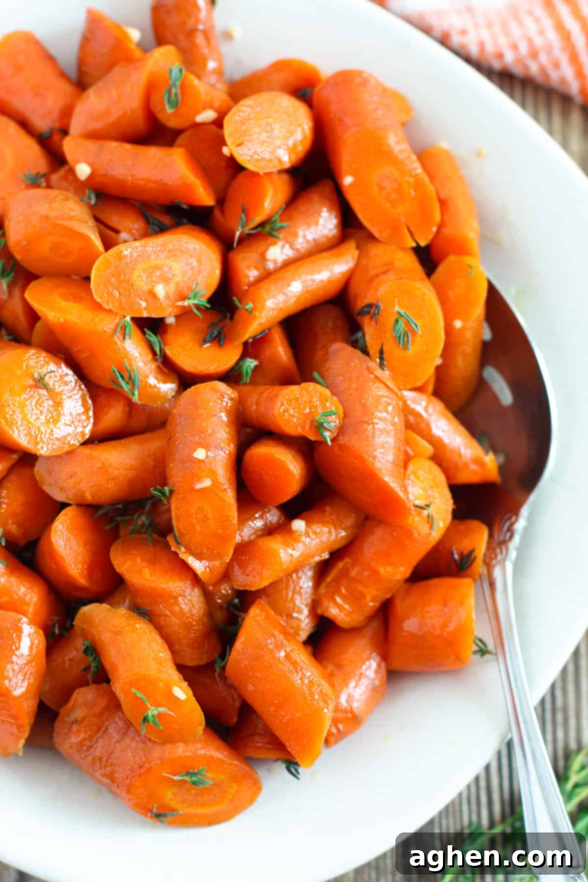Slow cooker glazed carrots with serving spoon, ready to be enjoyed.
