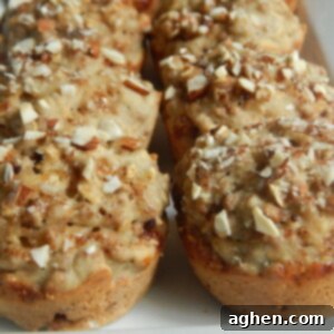 Close-up of a warm banana bran muffin, showing its texture and almond topping.