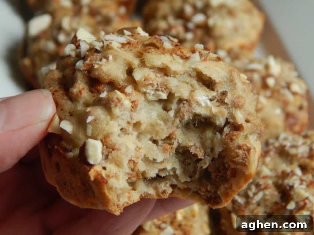 A close-up of a single banana bran muffin with a bite taken out, showing its fluffy interior.