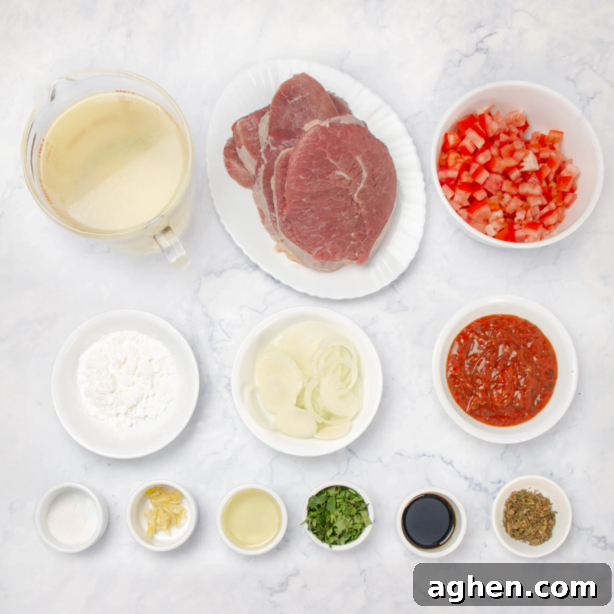 Swiss Steak ingredients laid out in separate dishes on a kitchen counter, ready for preparation.