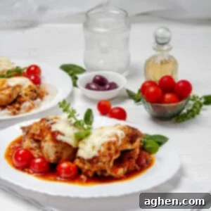 Weight Watchers' Favorite Chicken Caprese 8 Juicy and cheese Chicken Caprese on a plate with fresh tomatoes and olives on the side.