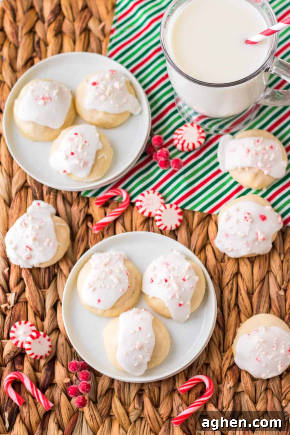 Frosted peppermint cookies on white plates and on straw tray beside a glass of milk. These Peppermint Meltaways are perfect for holiday celebrations.