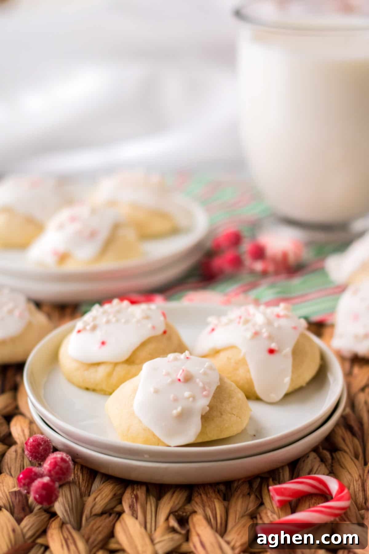 Close-up of Peppermint Meltaway cookies with white icing and crushed candy canes on top, showcasing their festive appeal.