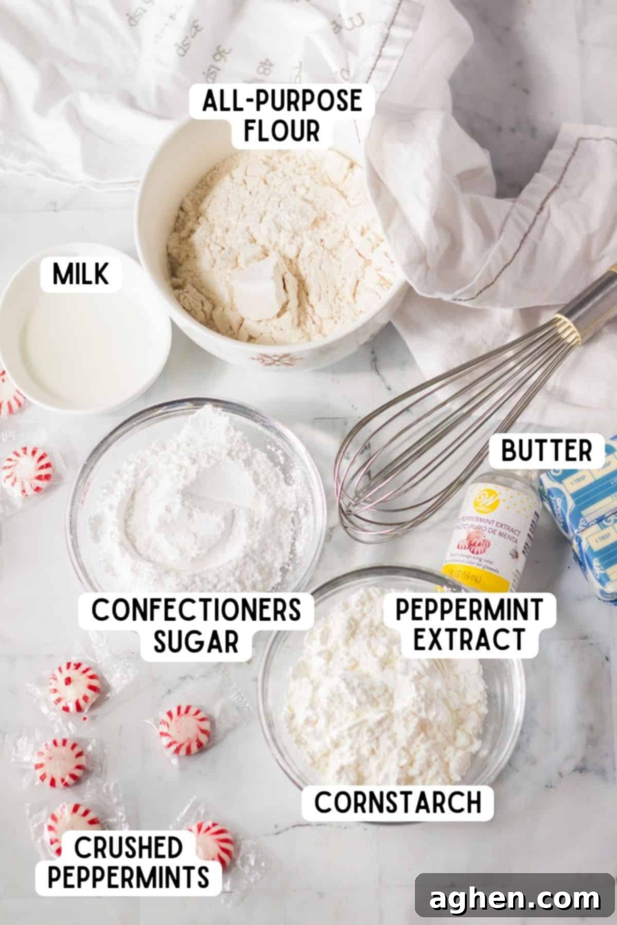 A flat lay of all the essential ingredients laid out for making peppermint meltaway cookies, including butter, flour, sugar, and peppermint extract.