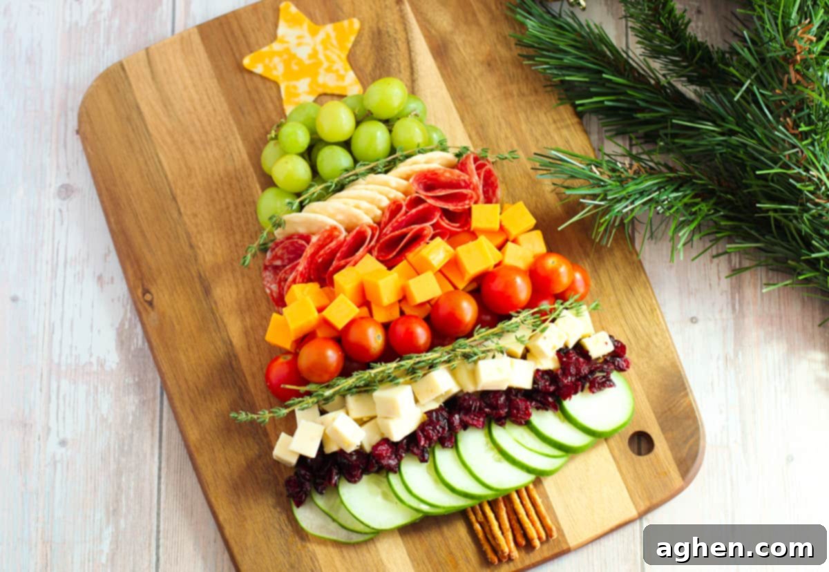 Close-up of a festive Christmas tree charcuterie board featuring a variety of colorful ingredients like cheese, cherry tomatoes, and sliced cucumbers.