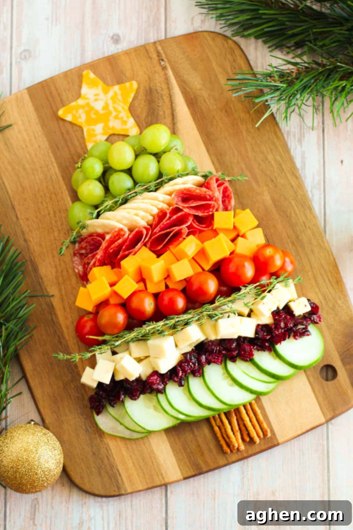 A beautifully arranged Christmas tree charcuterie board laden with cheese, salami, grapes, and crackers, ready for a festive gathering.