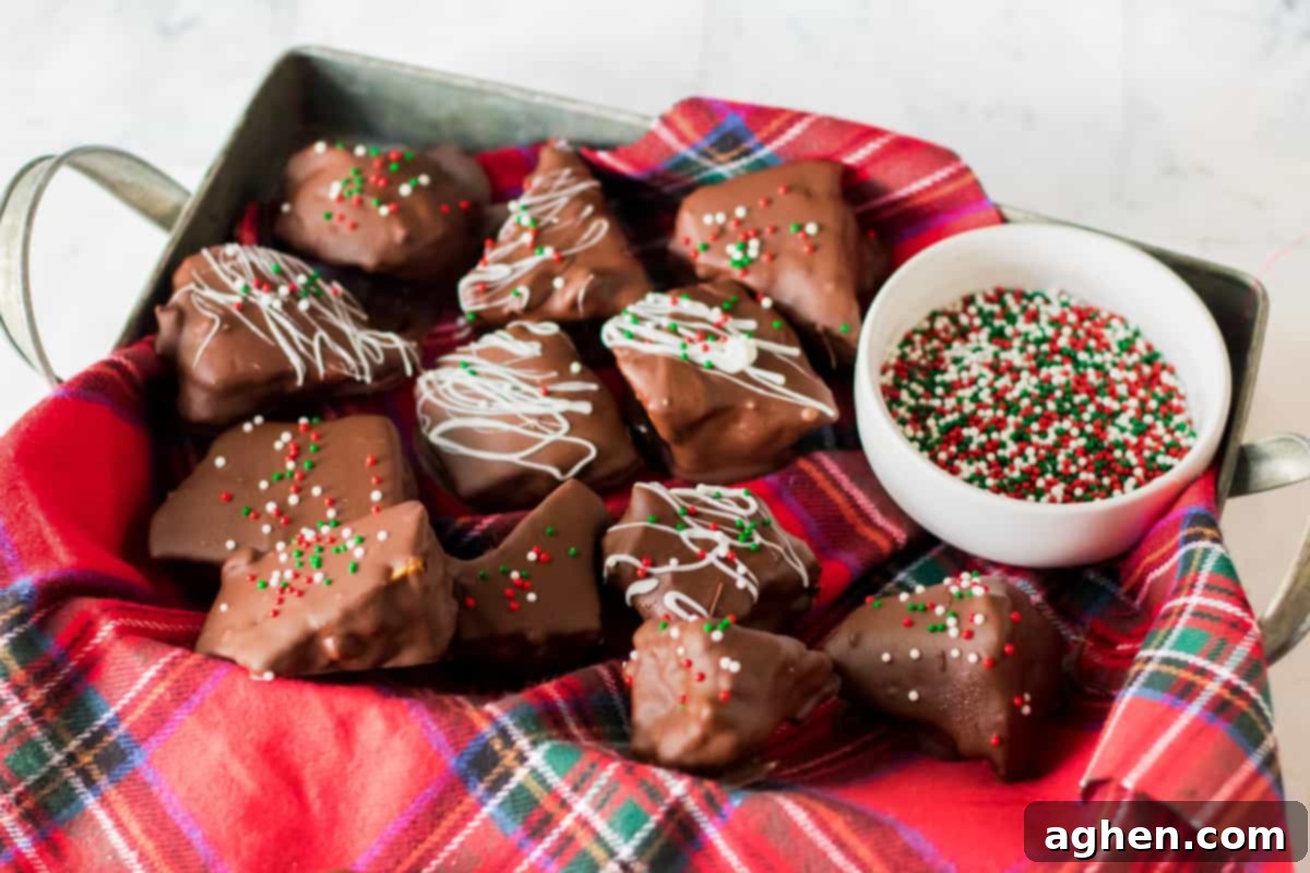 Chocolate coated honeycomb candy in napkin-lined tray with bowl of holiday sprinkles.
