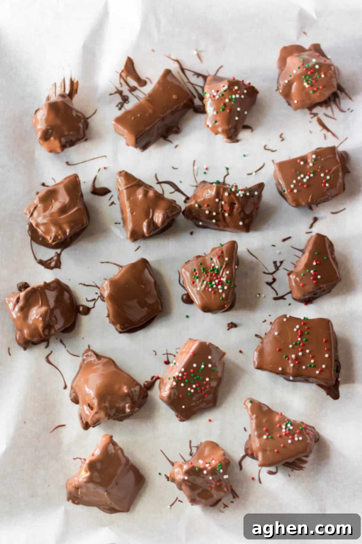 Chocolate covered honeycomb candy pieces on parchment paper.