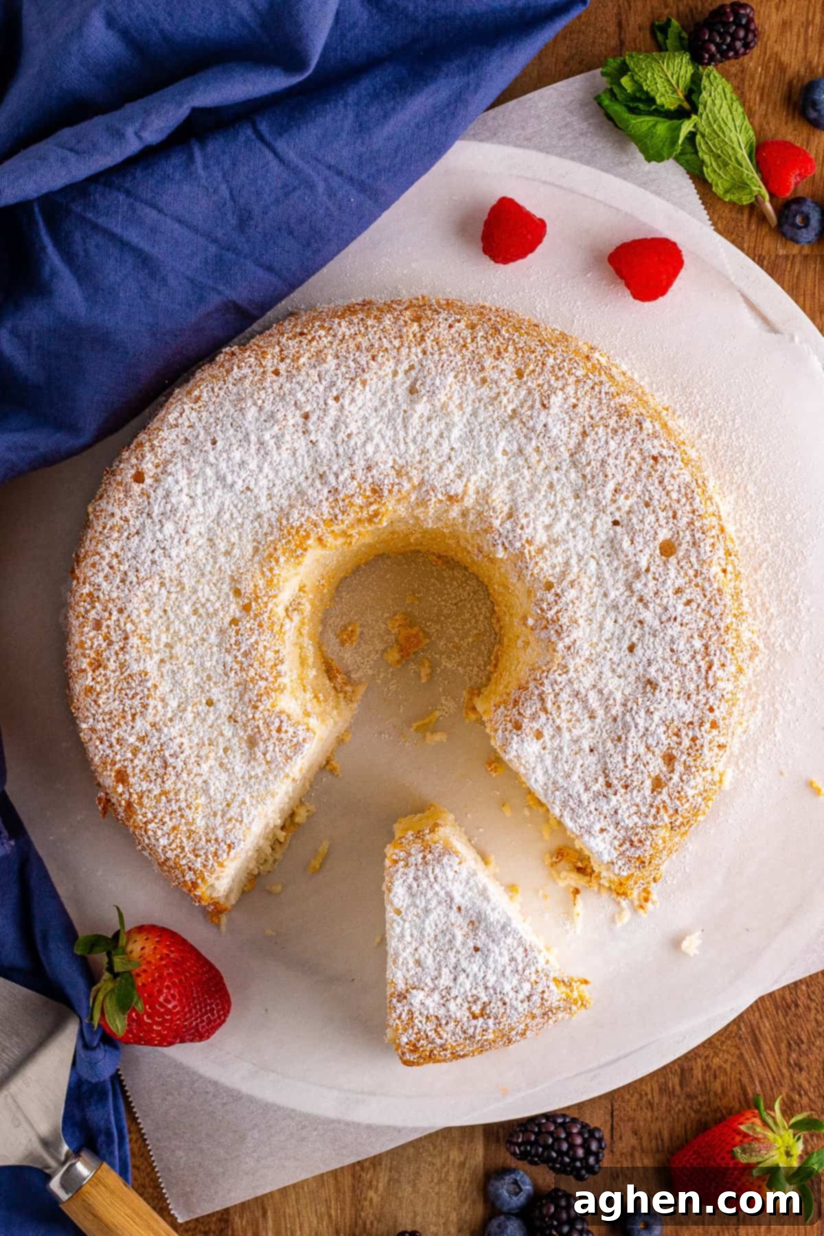 Top-down photo of top angel food cake dusted with confectioners sugar.