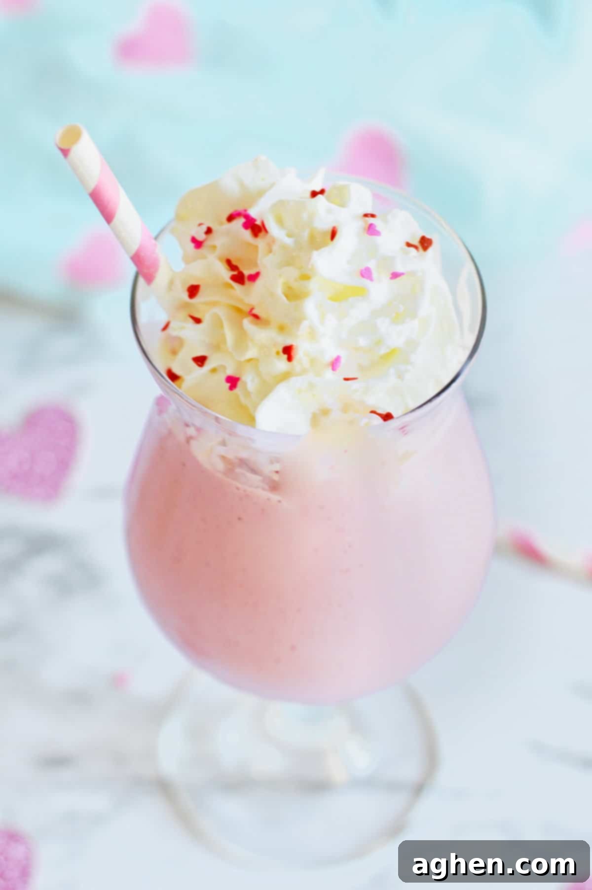 Pink mudslide cocktail with whipped cream and heart shaped sprinkles.