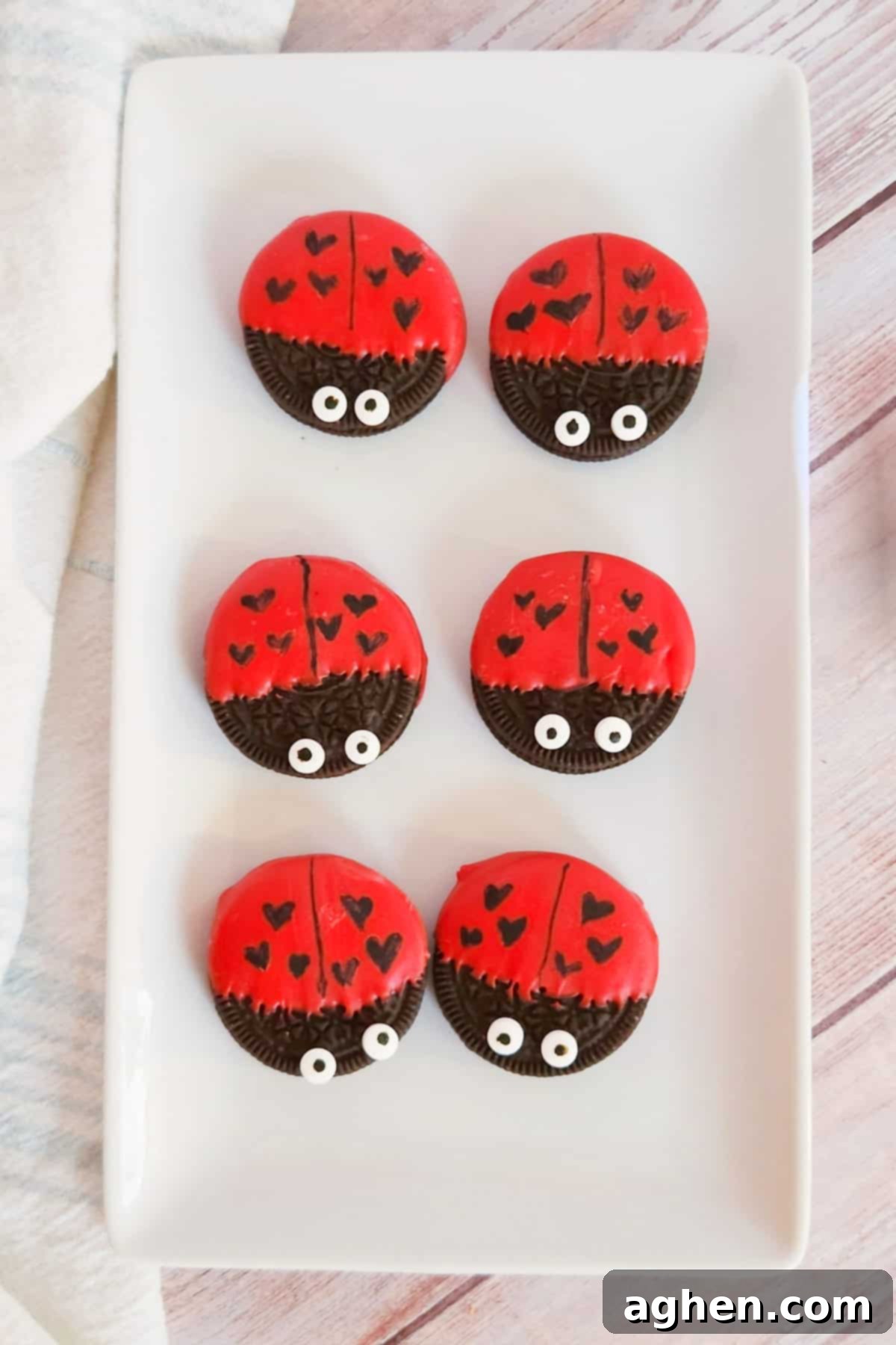 Oreo cookies dipped in red chocolate and decorated to look like ladybugs with heart spots for Valentine's Day.