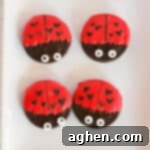 Oreo cookies dipped in red chocolate and decorated to look like ladybugs with heart spots for Valentine's Day.