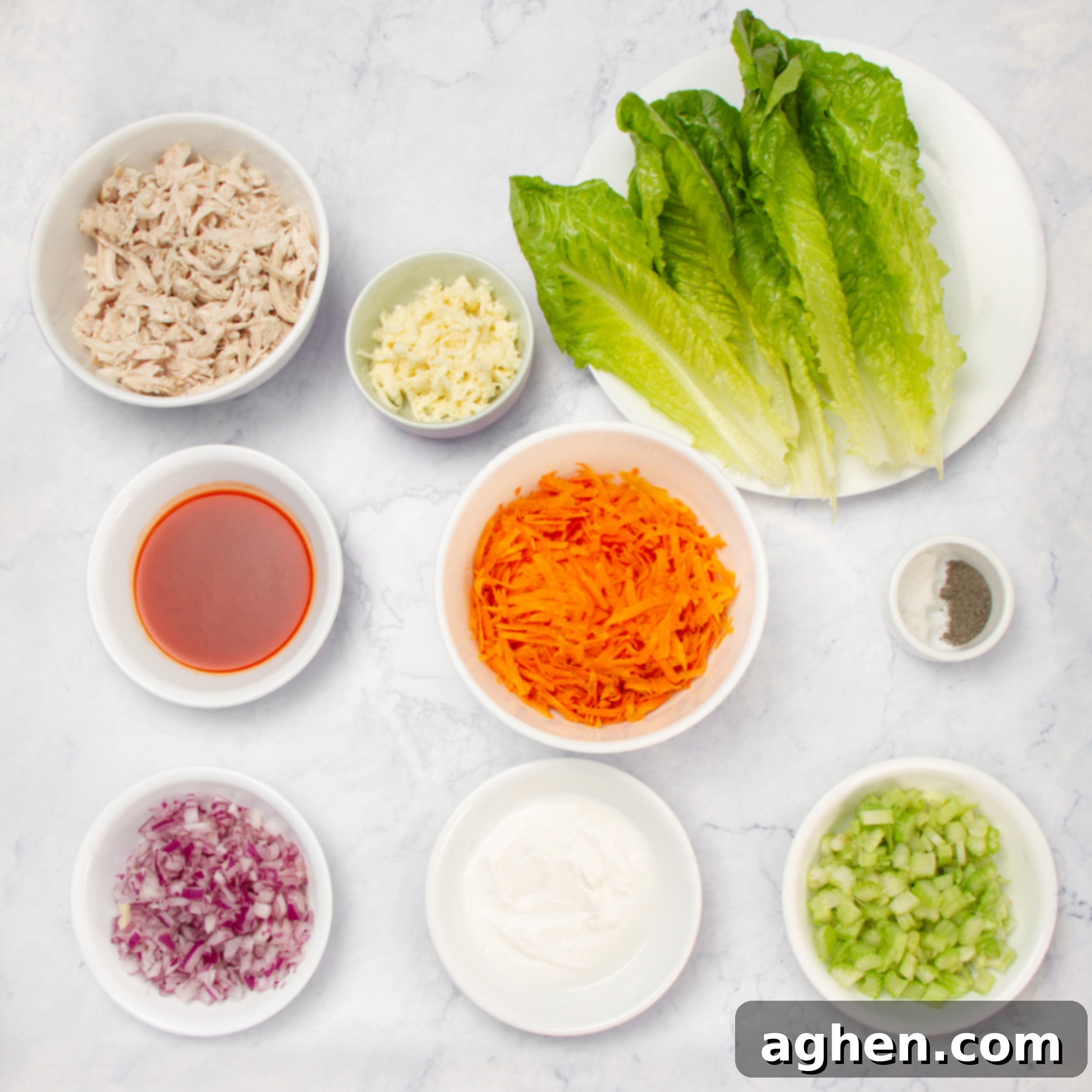 Deliciously Diet-Friendly Weight Watchers Buffalo Chicken Salad 3 Buffalo Chicken Salad ingredients laid out in separate dishes on a clean countertop, showcasing fresh celery, red onion, shredded chicken, and various dressing components.