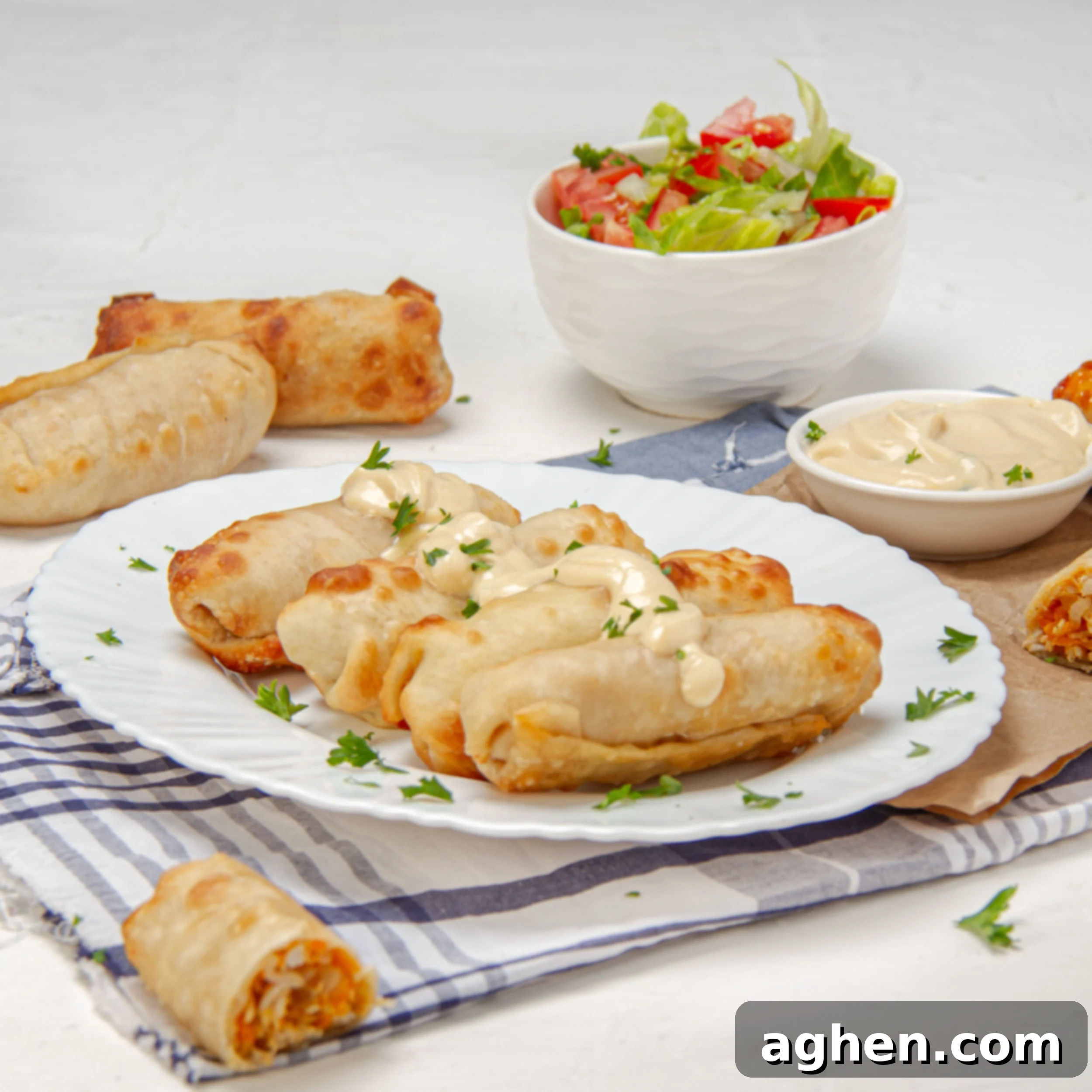 Crunchy and delicious Buffalo Chicken Egg Rolls on a plate with a salad on the side.