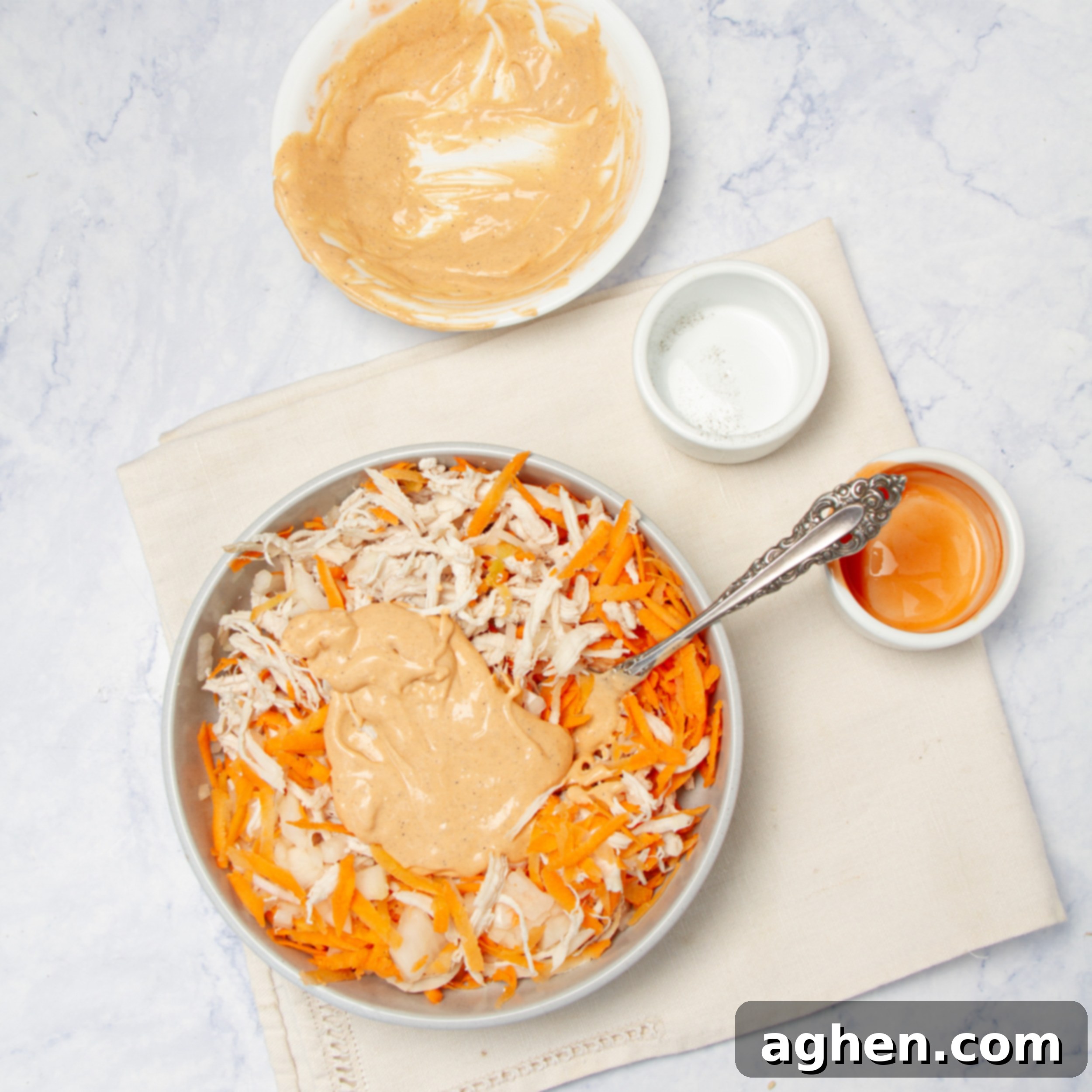 Combining the buffalo dressing with shredded vegetable ingredients. 
