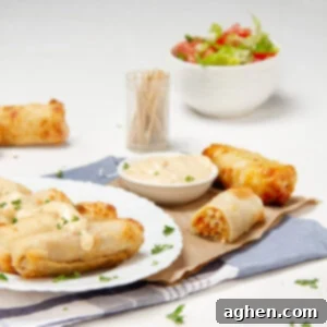 Crunchy and delicious Buffalo Chicken Egg Rolls on a plate with a salad on the side.