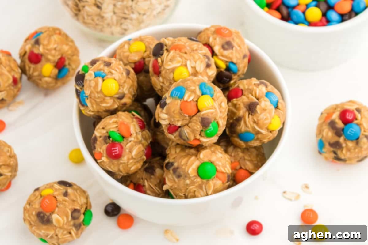 A wider shot of a bowl filled with monster oatmeal balls, featuring visible chocolate chips and M&Ms, ready to be enjoyed.