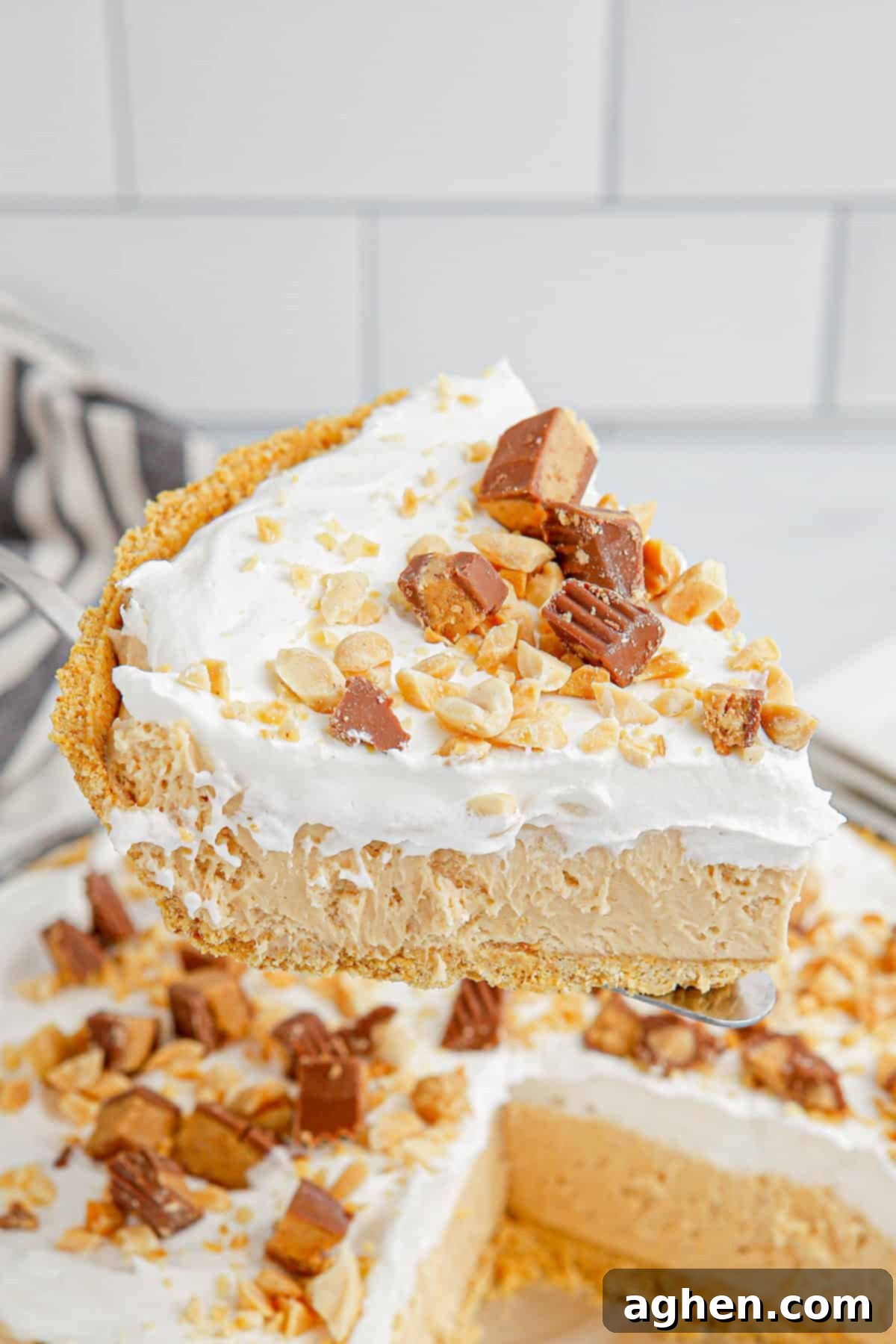 Slice of easy no bake peanut butter pie being lifted from pie, showcasing its creamy layers.