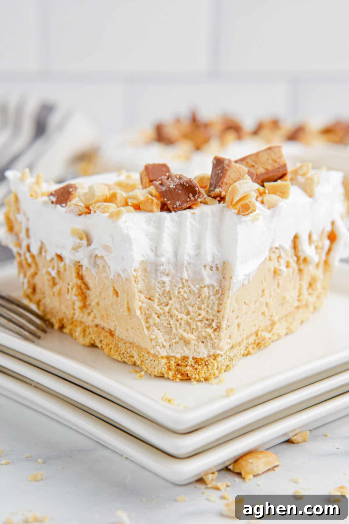 No-bake peanut butter pie with fork marks where one bite has been removed, highlighting its smooth texture.