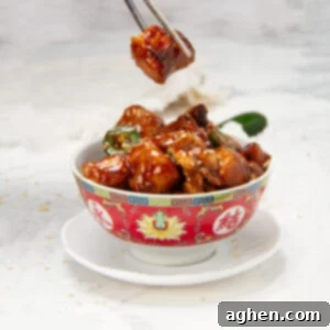 Healthy general Tso's chicken in a bowl with sesame seed garnish.