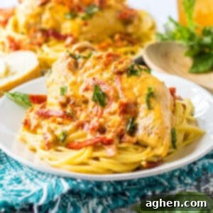 Slow cooker marry me chicken breasts with creamy sun-dried tomato sauce and fresh basil over spaghetti.