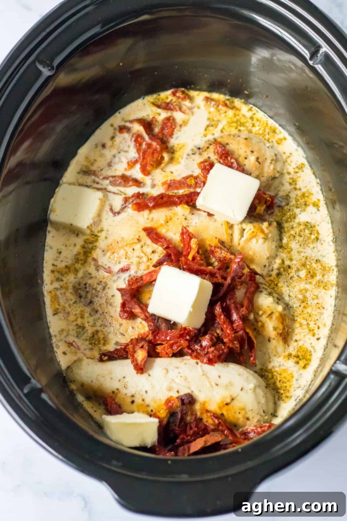 Chicken breasts with cream sauce, sun dried tomatoes, and butter in the crockpot.