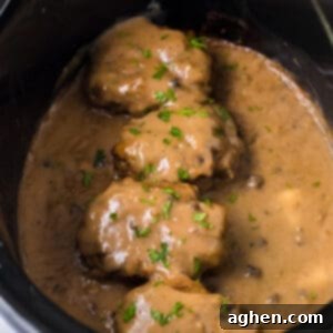 Easy Slow Cooker Salisbury Steaks 11 Slow cooker salisbury steaks smothered with brown gravy and garnished with parsley in a crockpot.