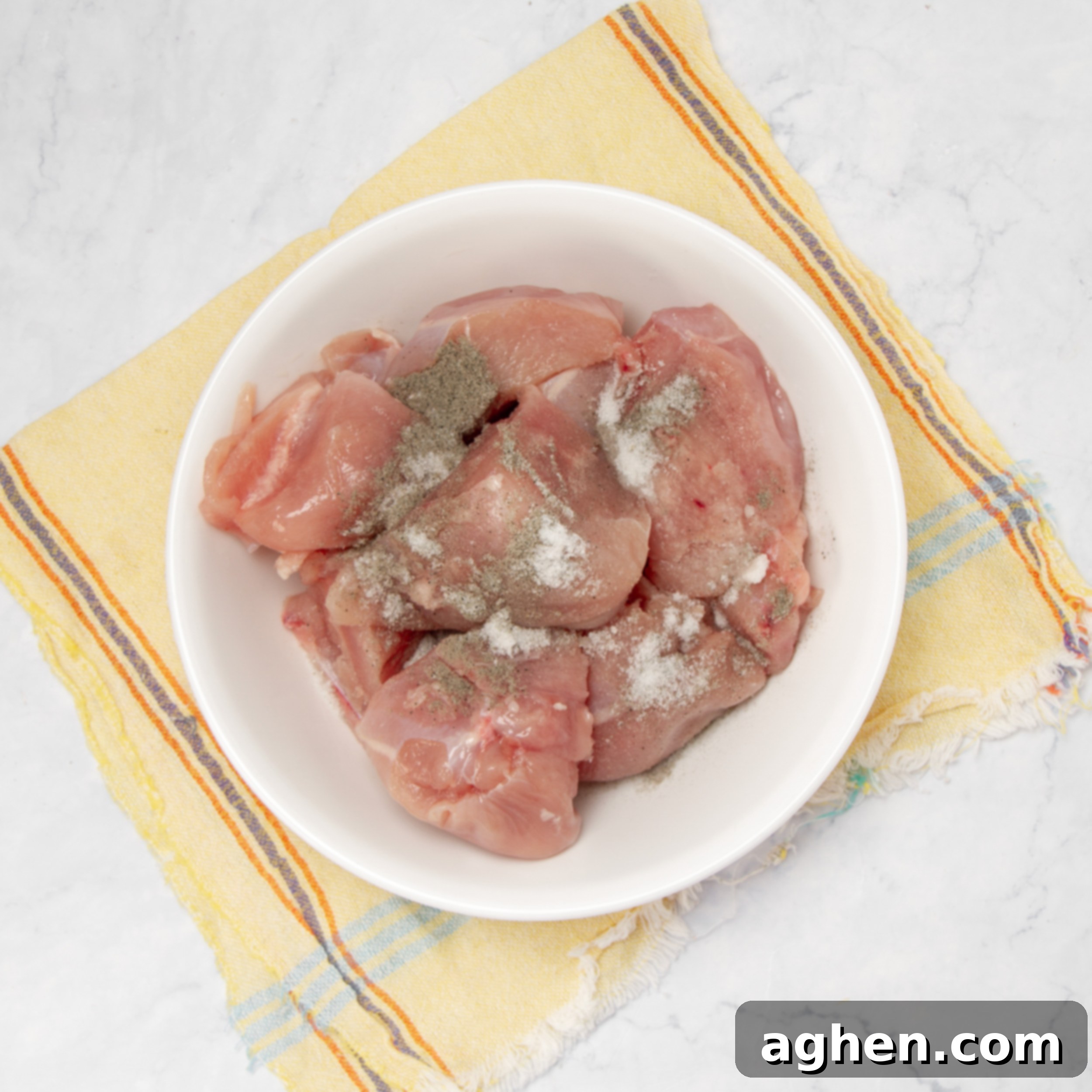 Napoleonic Chicken 4 Raw chicken breast chunks seasoned with salt and pepper, marinating in a small bowl, ready for the initial searing step.