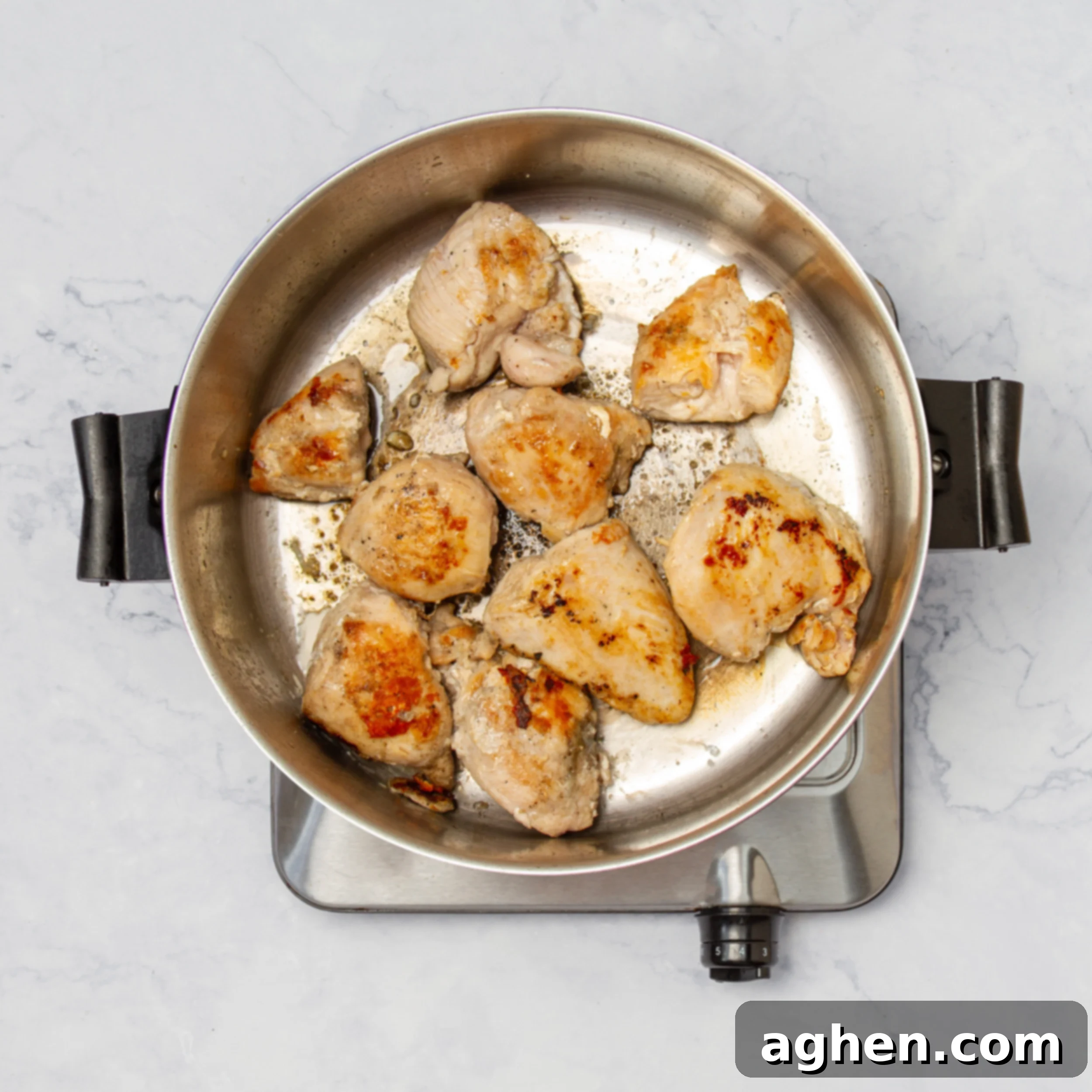Napoleonic Chicken 5 Seasoned chicken pieces searing to a beautiful golden brown in a hot pan, illustrating the critical browning step for maximum flavor development in the stew.