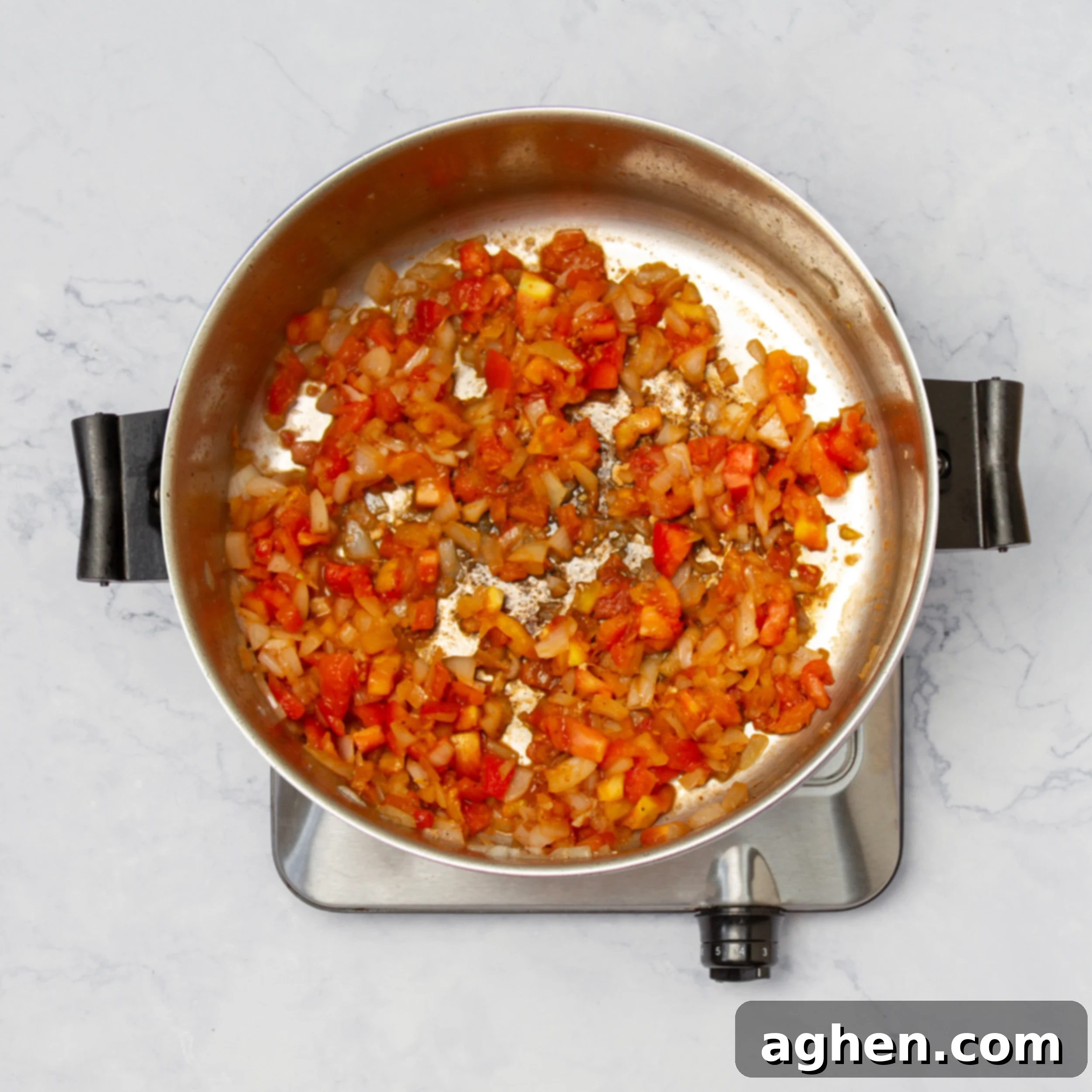 Napoleonic Chicken 6 Aromatic diced onions and fresh tomatoes cooking until translucent and soft in the pan, forming the rich, fragrant base for the Chicken Marengo sauce after the chicken has been removed.