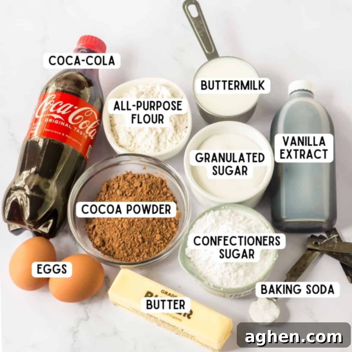 Decadent Double Chocolate Coca Cola Cake 4 An organized display of key ingredients for making the chocolate Coca-Cola cake: a bottle of Coca-Cola, a bag of all-purpose flour, cocoa powder, a bottle of vanilla extract, a carton of buttermilk, a stick of butter, baking soda, two fresh eggs, granulated sugar, and confectioner's sugar.