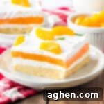 Velvet Orange Dream 11 Orange creamsicle lush with layers of creamy vanilla pudding and orange jello, sweetened cream cheese, and cool whip on a sweet cookie crust. Mandarin orange pieces top the no bake cake.
