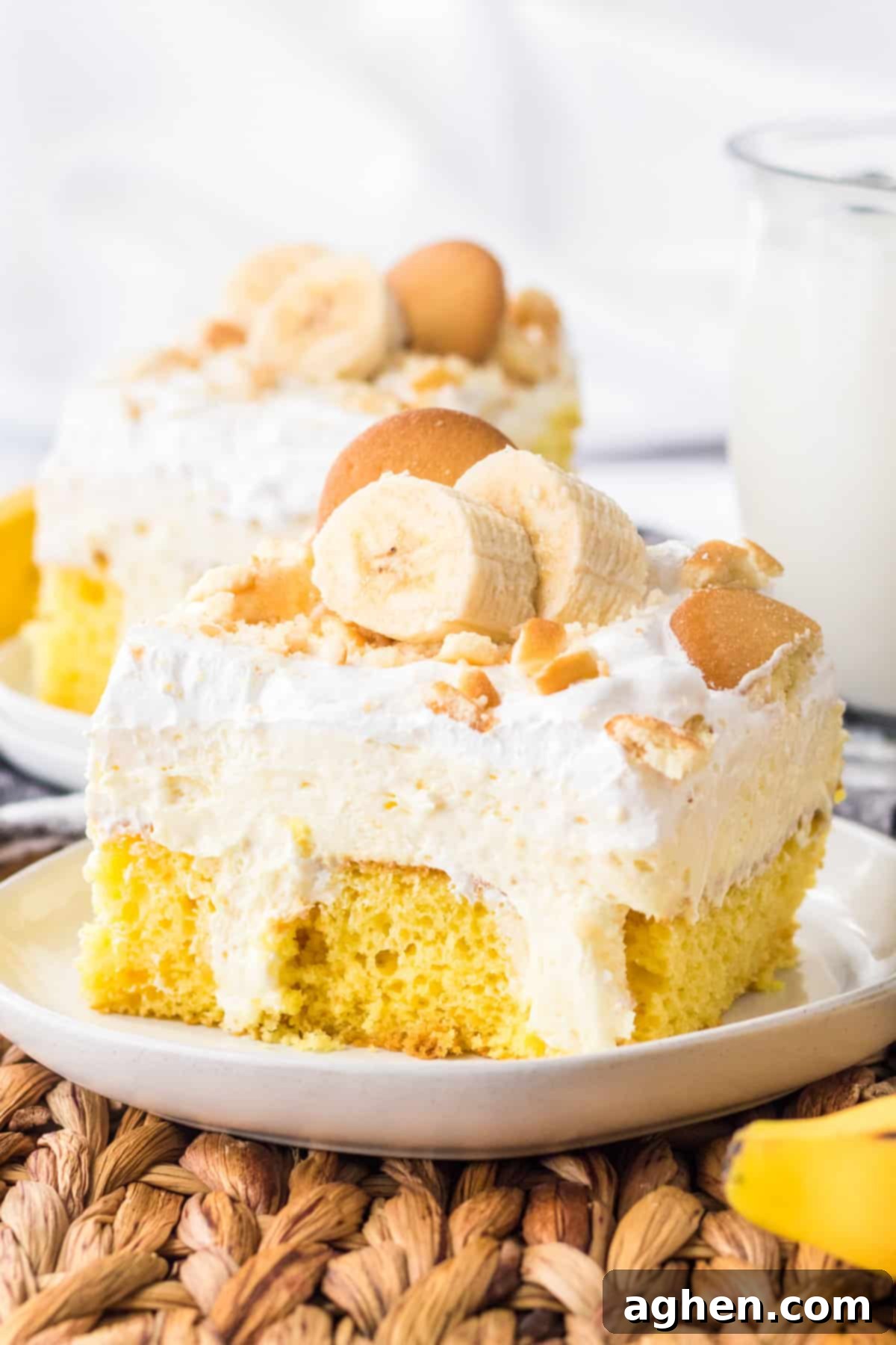 Banana Cream Dream Poke Cake 2 A stunning banana pudding poke cake, beautifully topped with fresh banana slices and classic Nilla wafers. The creamy layers are visible, promising a delightful texture and flavor.