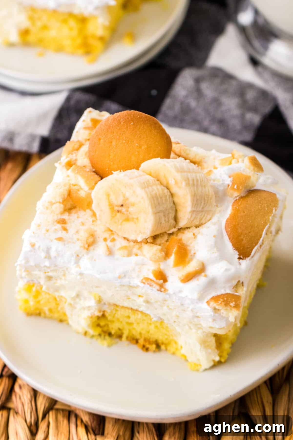 Banana Cream Dream Poke Cake 10 A vibrant banana poke cake showcasing its layers of moist yellow cake, creamy banana pudding filling, fluffy Cool Whip, and a generous topping of Nilla wafers and fresh banana slices, ready to be enjoyed.