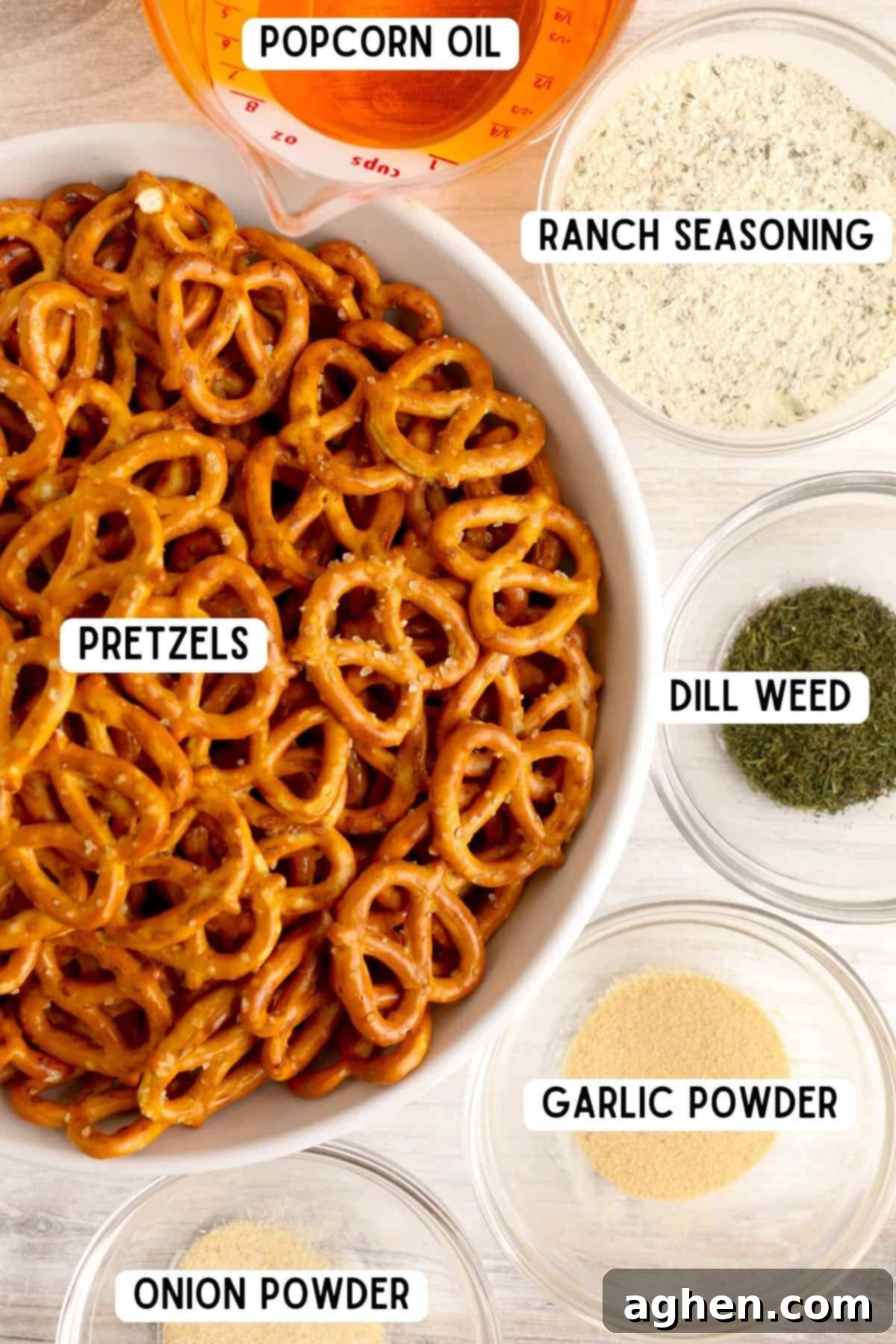A flat lay image displaying mini pretzel twists, a bottle of popcorn oil, a packet of ranch seasoning, garlic powder, dill weed, and onion powder, ready for making seasoned pretzels.
