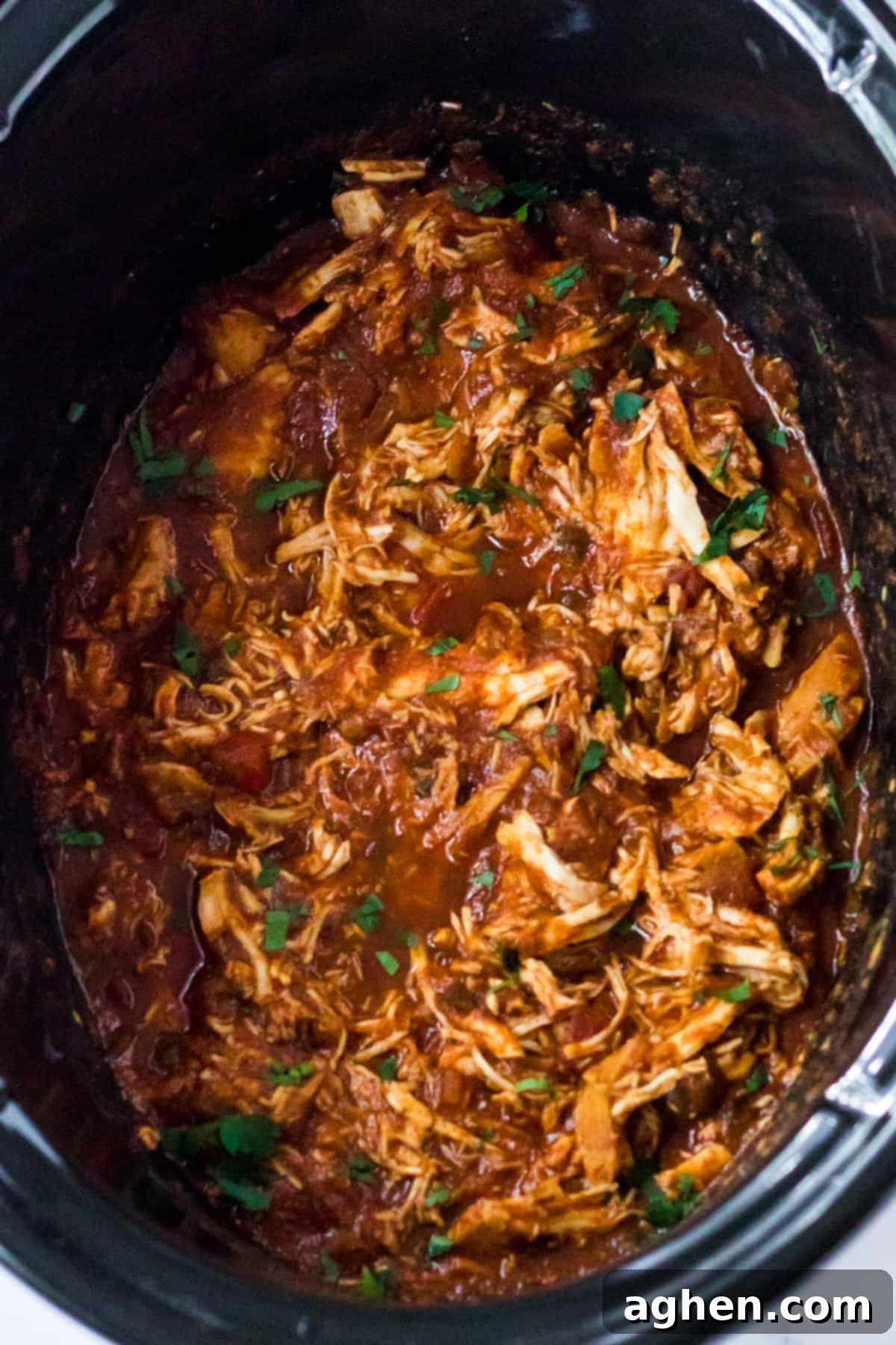 Slow cooker salsa chicken shredded in the bowl of a crockpot.