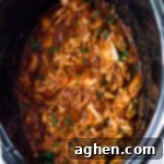 Slow cooker salsa chicken shredded in the bowl of a crockpot.