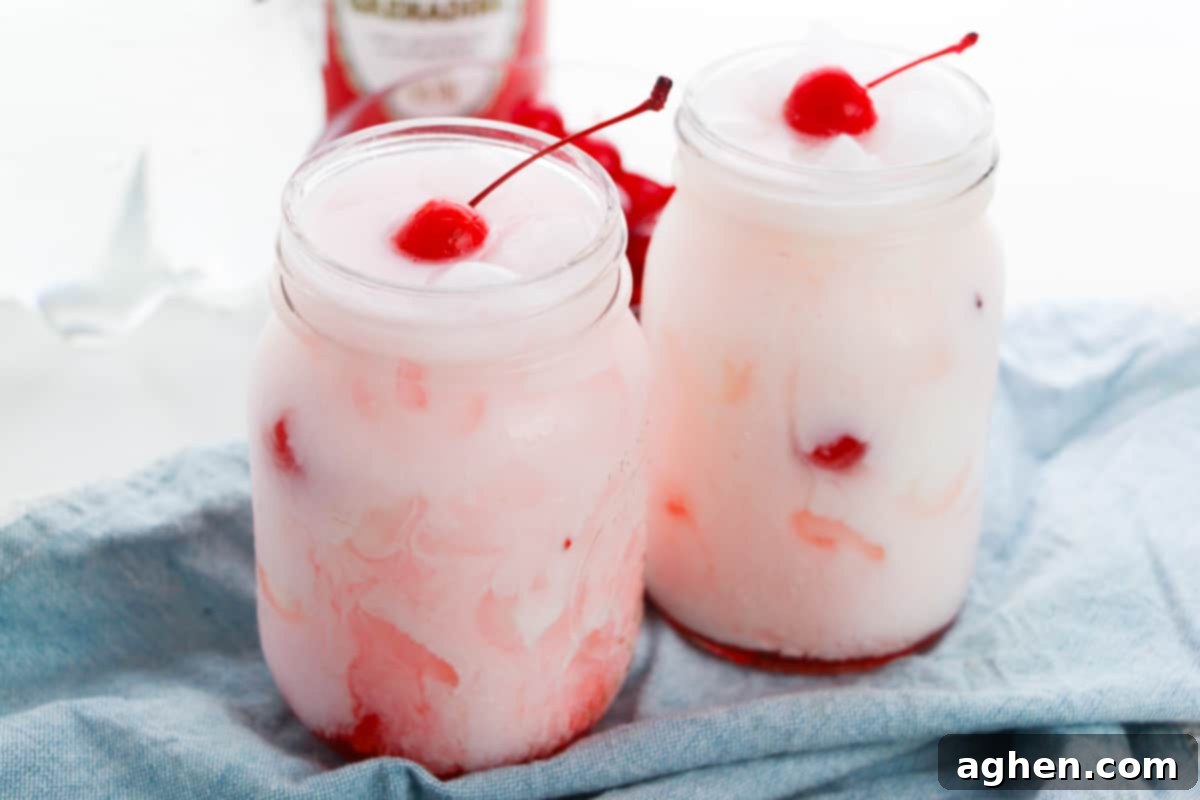 Shirley temple dirty sodas garnished with cherries in two mason jars.