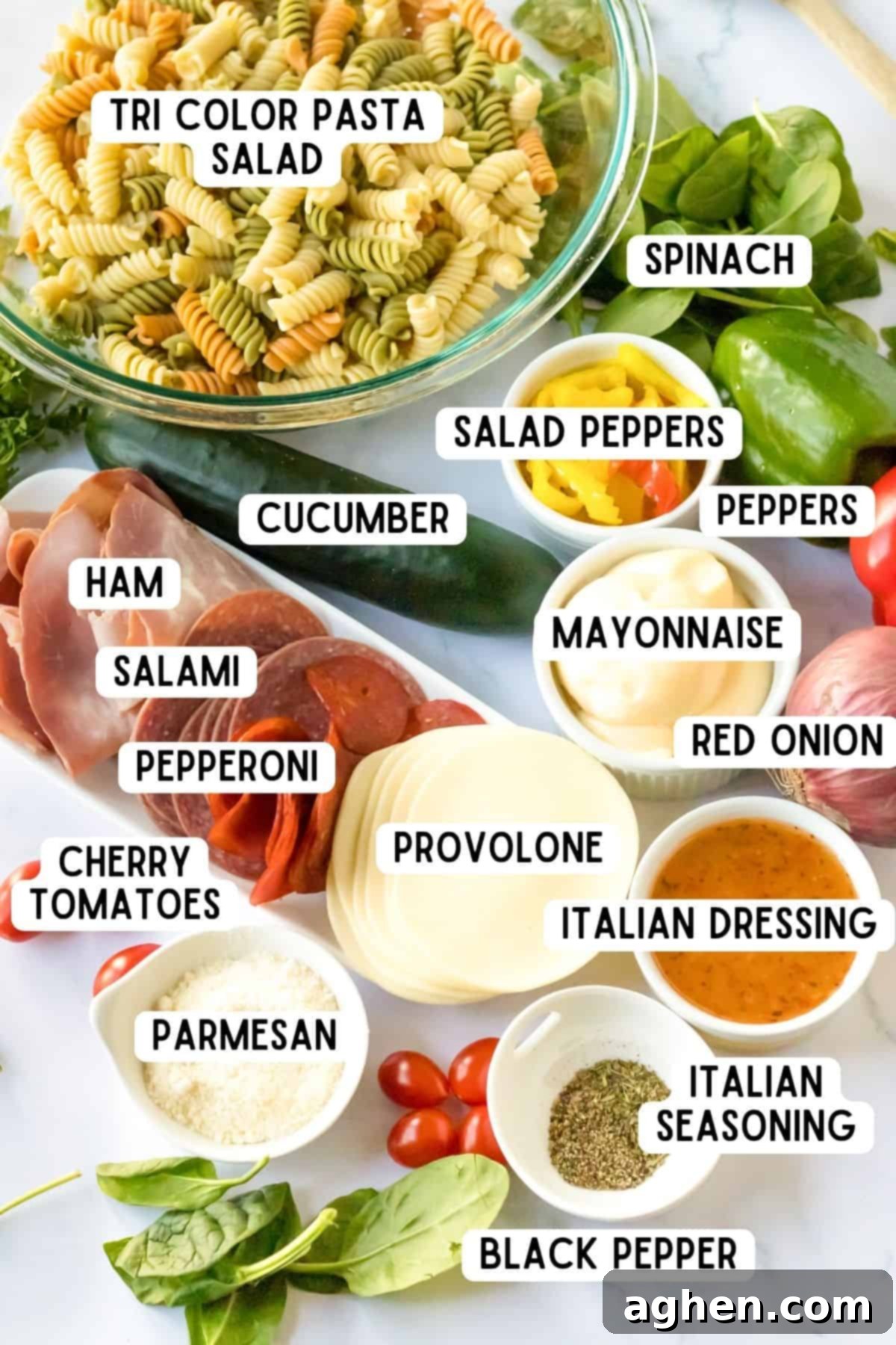 Tri-color rotini, red and green peppers, salad peppers, ham, salami, pepperoni, fresh spinach, mayonnaise, italian dressing, sliced provolone, grated parmesan, black pepper, Italian seasoning, red onion, cucumber, cherry tomatoes. 