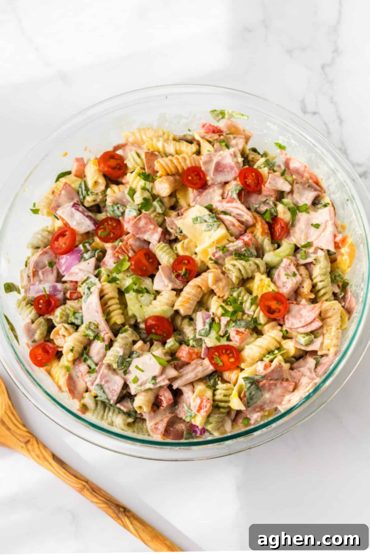 Coat meat pasta salad in glass bowl.